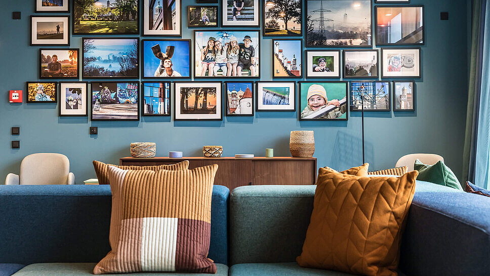 Hotellobby: Sofas, Sessel, eine Bildergalerie auf blauer Wand
