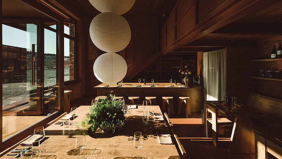 Blick ins Restaurant aerde mit Holztischen und kugelförmigen Lampen