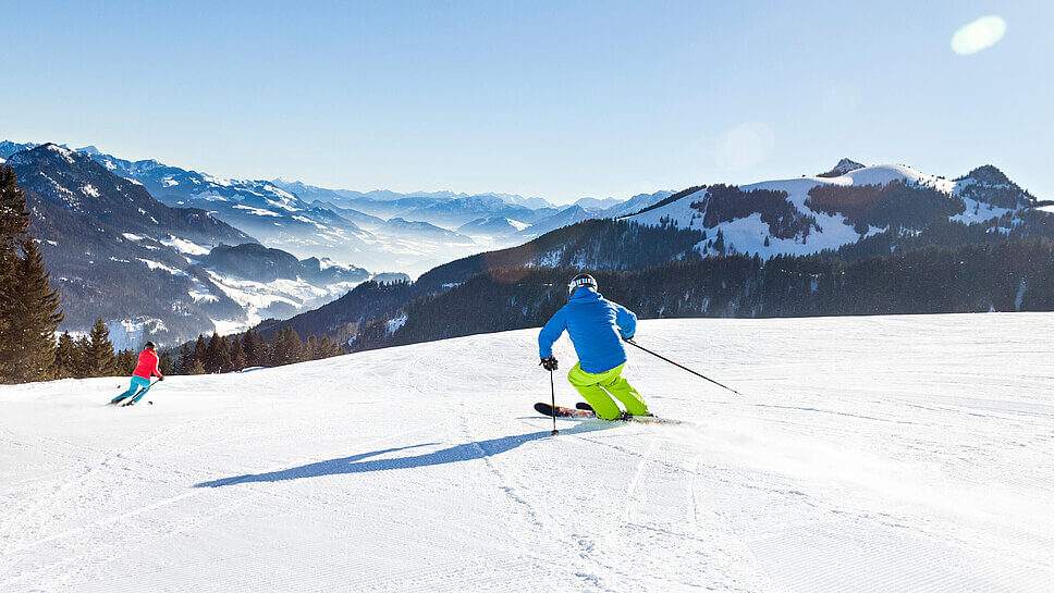 Skifahrer:innen von hinten auf der Piste in Sudelfeld in Oberbayern