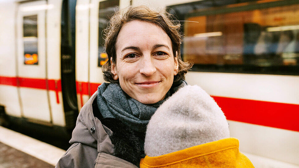 Natascha Wegelin am Bahngleis, mit Kind im Arm