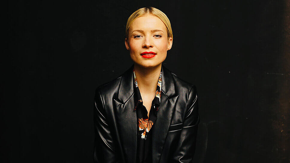 Frontales Porträtfoto von Lena Cassel vor schwarzem Hintergrund